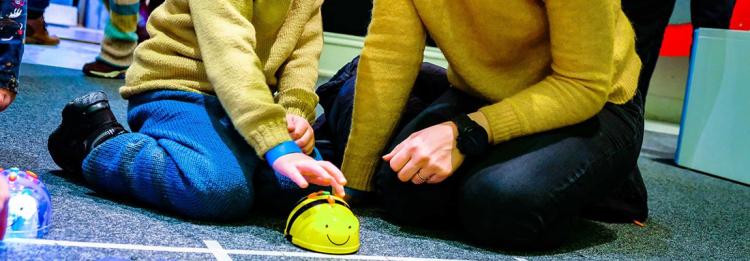 Foto av barn og voksen som leker med Beebot